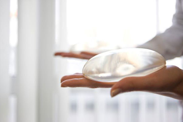 Woman holding breast implants
